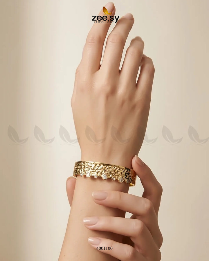 Sculptural textured crystal cuff bracelet by MH26 featuring intricate design and shimmering crystals on a metallic band.