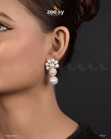 Akoya Earrings exquisite earrings feature a luxurious arrangement of pearls and diamond-cut stones, offering a perfect blend of elegance and sophistication. These Ethnic Festive Earrings top cluster design is adorned with shimmering stones, while the gracefully dangling pearls enhance the charm and femininity of the piece. Ideal for special occasions.