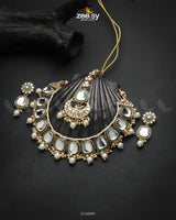 The Aqsa Necklace Set is an exquisite choker-style masterpiece that blends antique charm with traditional Kundan artistry. Showcasing high-quality Kundan stones set in an intricately crafted frame, this set exudes timeless elegance. The vintage-inspired detailing and delicate embellishments enhance its regal appeal, making it a perfect choice for weddings, festive occasions, and cultural celebrations.