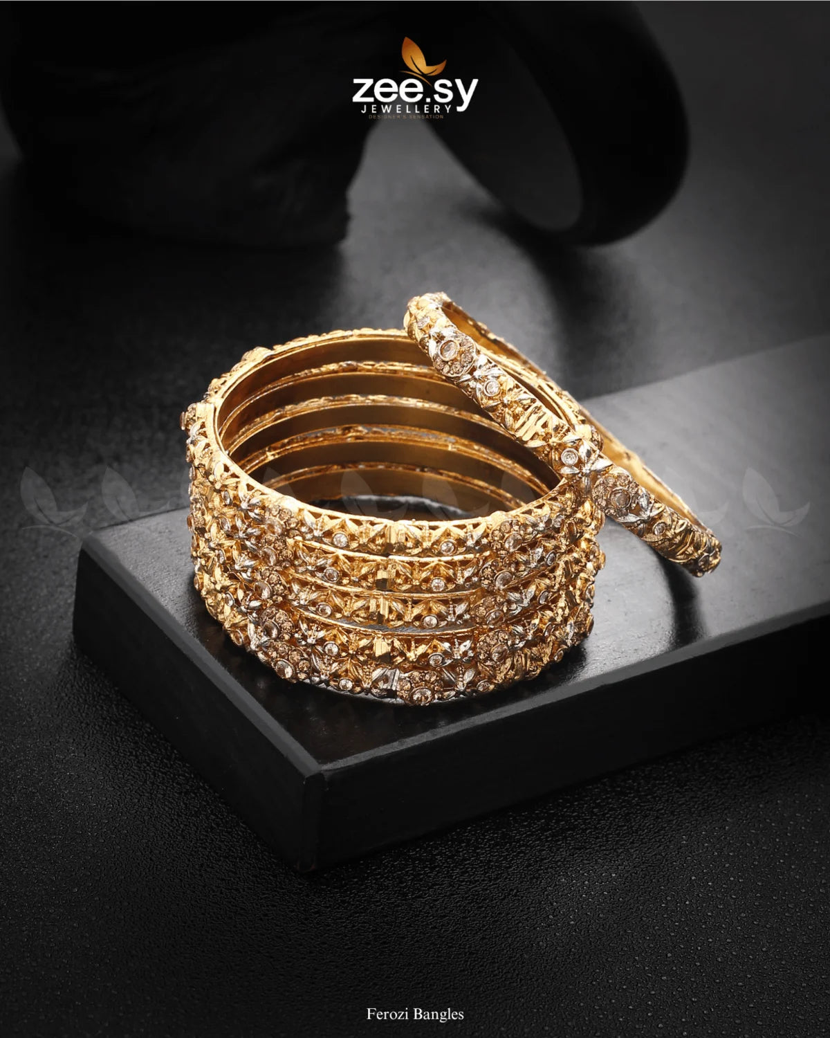 Ferozi Bangles are intricately designed bangles showcase exquisite craftsmanship with beautifully embedded shimmering stones, creating a luxurious and timeless appeal. The textured detailing and symmetrical stone placements enhance their charm, making them a perfect accessory for weddings, festive occasions, and traditional wear.