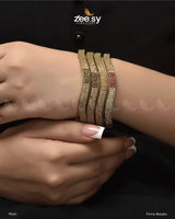 Florus Bangles, offered in Multi and Champagne variants. These stunning kangans are encrusted with dazzling American Diamond stones, adding a touch of brilliance. The Multi variant features subtle colored accents, while the Champagne exudes a soft, luxurious glow. This kada is perfect for weddings, festive occasions, and special celebrations.