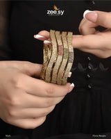 Florus Bangles, offered in Multi and Champagne variants. These stunning kangans are encrusted with dazzling American Diamond stones, adding a touch of brilliance. The Multi variant features subtle colored accents, while the Champagne exudes a soft, luxurious glow. This kada is perfect for weddings, festive occasions, and special celebrations.