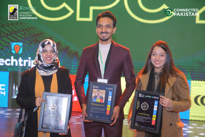 Three individuals holding awards on a stage with 'Connected Pakistan' branding in the background