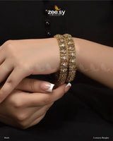 Lonicera Bangles, available in Golden and Multi variants. These exquisite kangans are embellished with dazzling diamond-cut stones and crystal glass stones, adding a touch of brilliance. The Golden version exudes timeless elegance, while the Multi variant brings a vibrant charm, this is a stunning addition to any grand occasions.