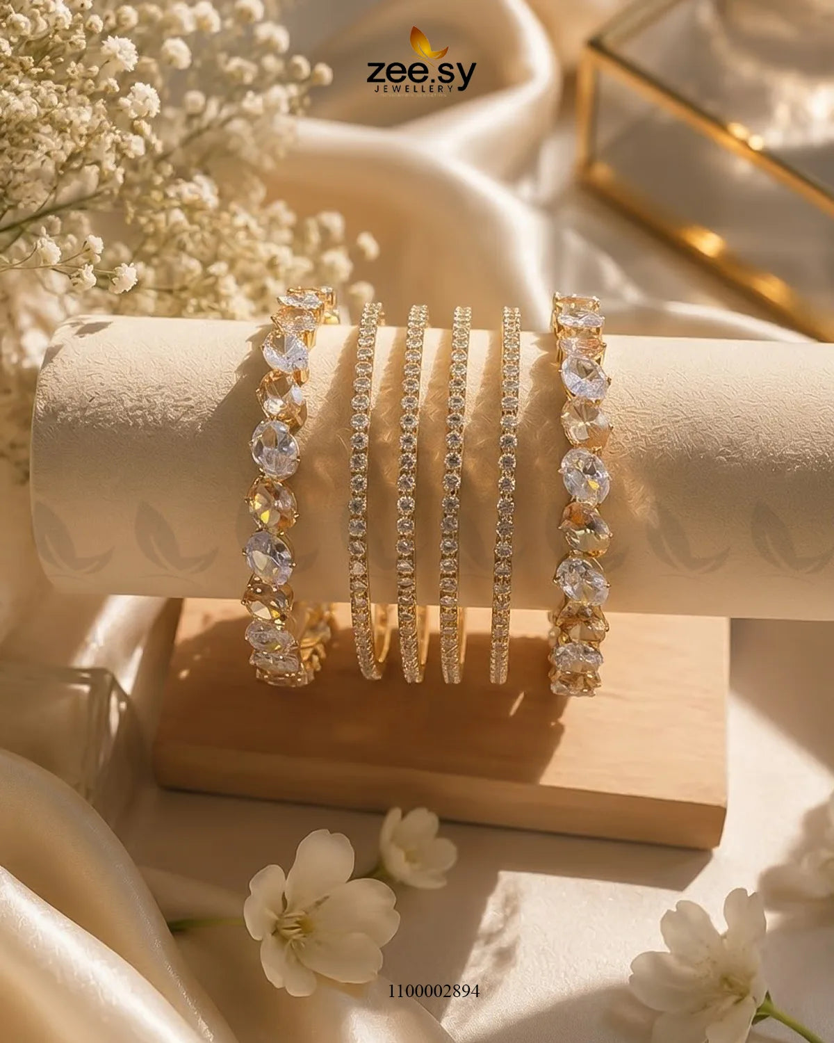 AJ03 oval gemstone paved bangles featuring shiny oval gemstones and intricate metalwork in a champagne color.