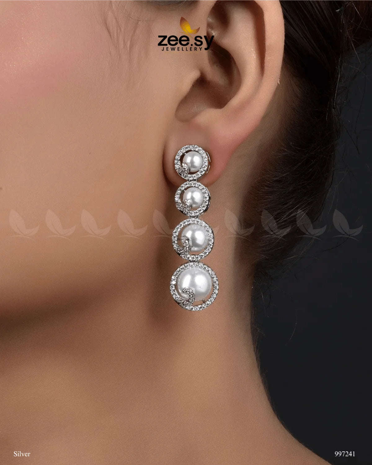 Simulated Earrings embody elegance and sophistication with their luxurious design. Featuring a dazzling arrangement of American-cut diamond stones, Vintage Pearl Earrings are adorned with luminous pearls in a cascading pattern, creating a graceful and timeless look. The refined setting is complemented by a golden or silver polish, adding a radiant finish that enhances their beauty.