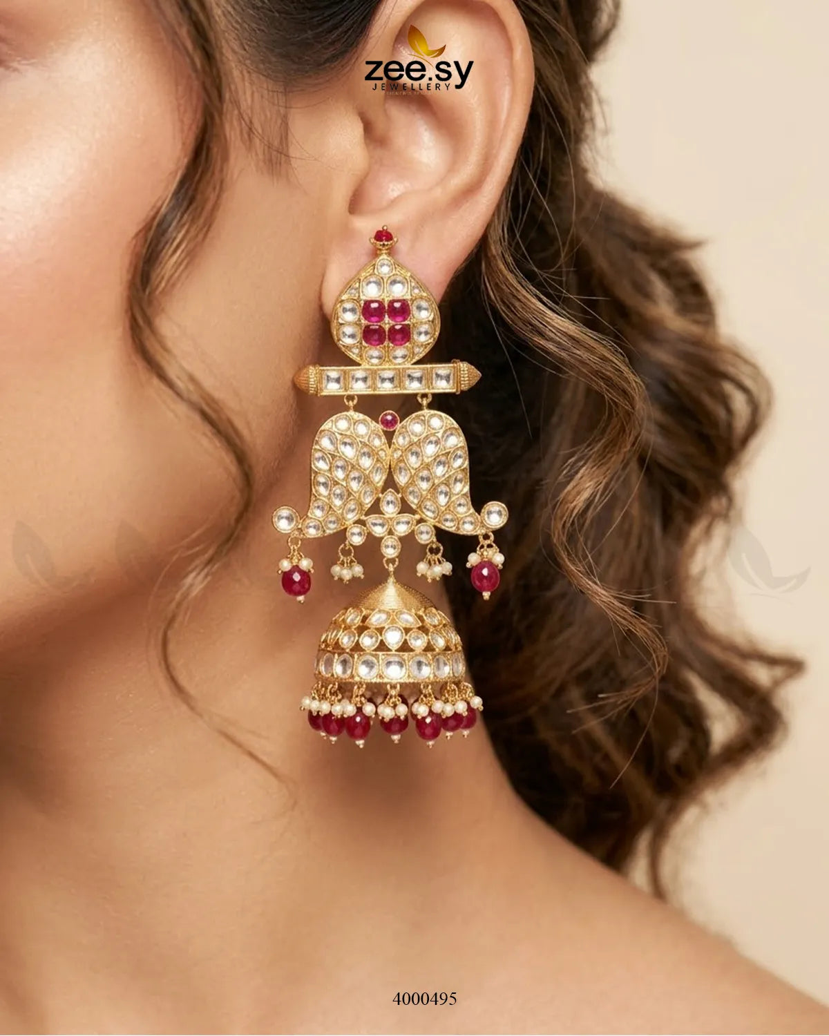 Traditional Polki Jhumki earrings with intricate gold detailing and dangling pearl accents, showcasing elegant Indian jewelry design.
