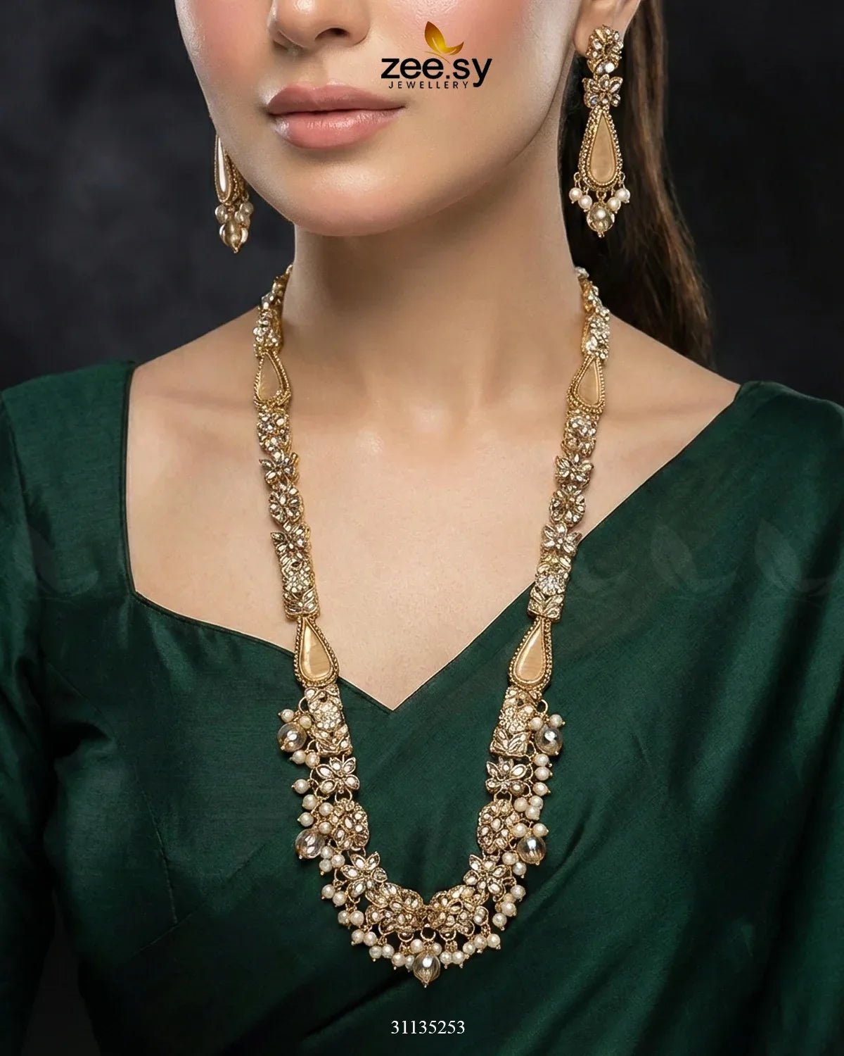 Woman wearing a gold necklace and earrings with a dark background, featuring the zee sy brand.