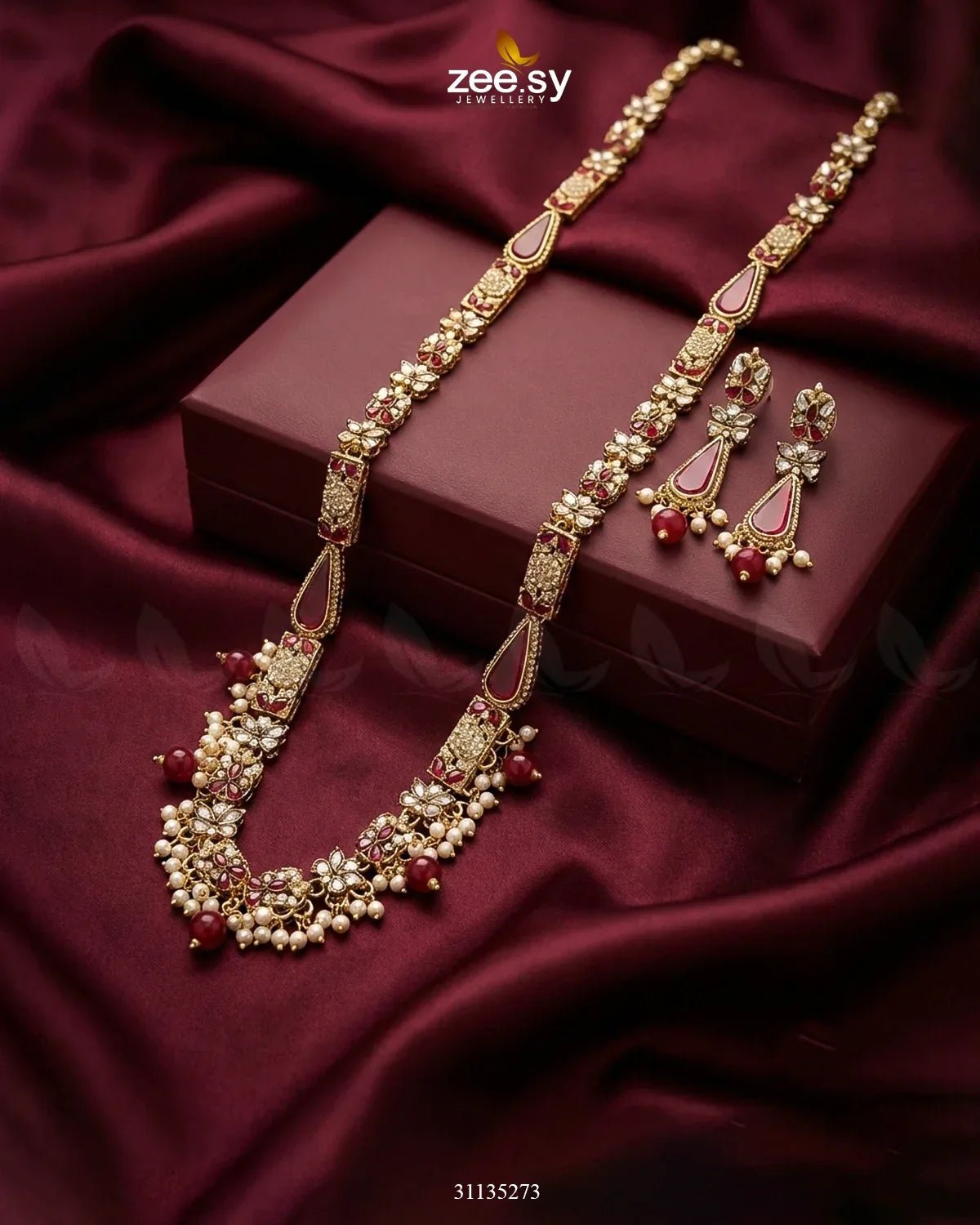 Ornate necklace and earrings set on a maroon fabric background with 'zee sy' branding.