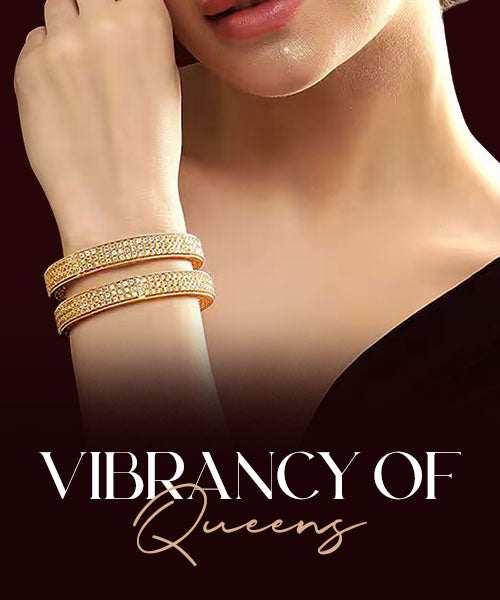 Woman wearing gold bangles against a dark background