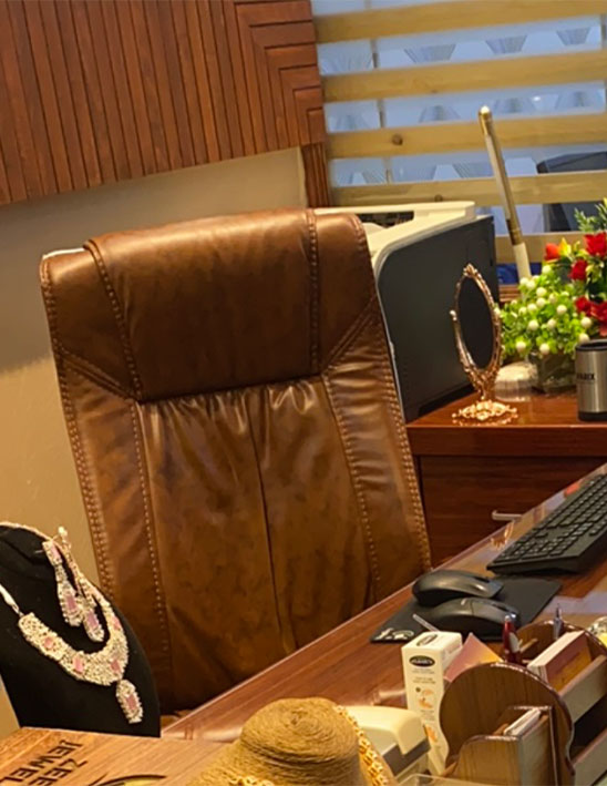 Luxury jewelry office workspace with leather executive chair, wooden desk, necklace display, and elegant interior